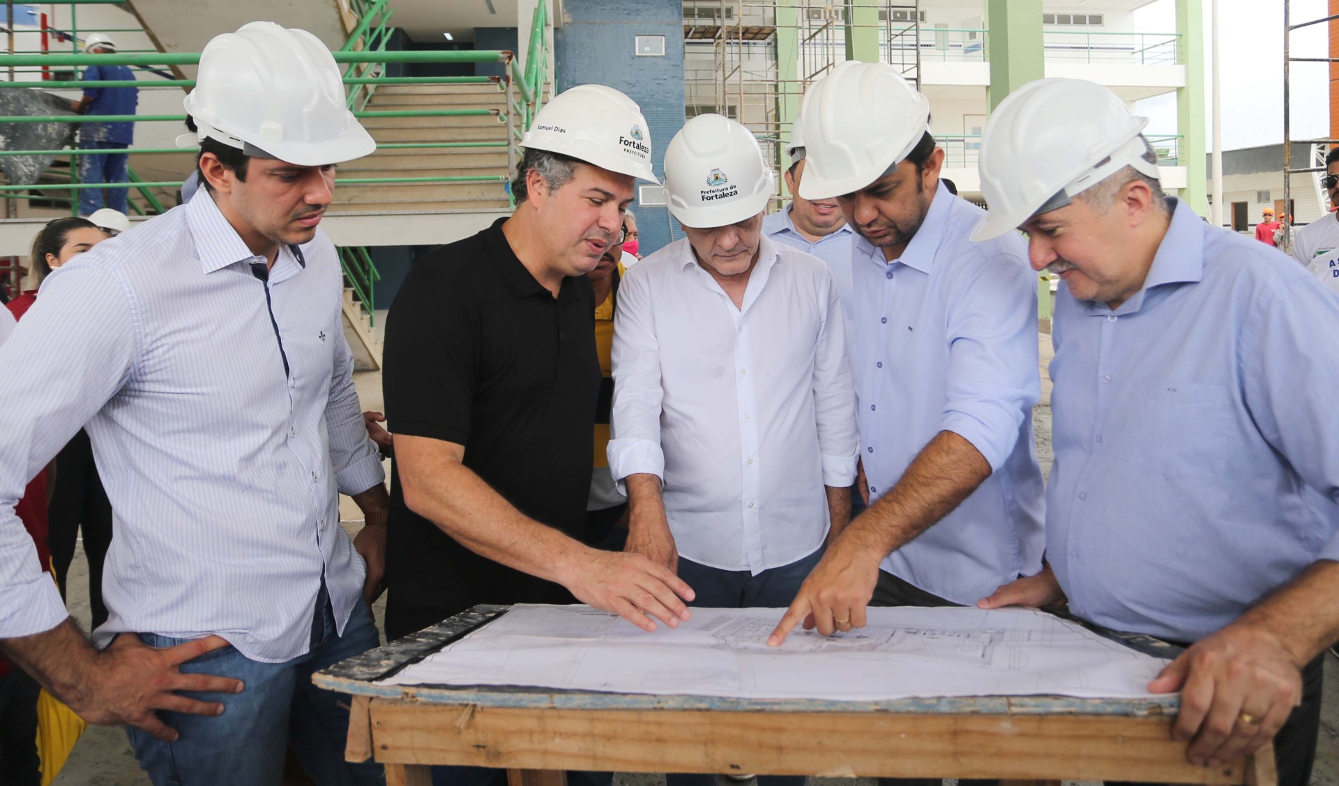 sarto olha a planta da escola em construção